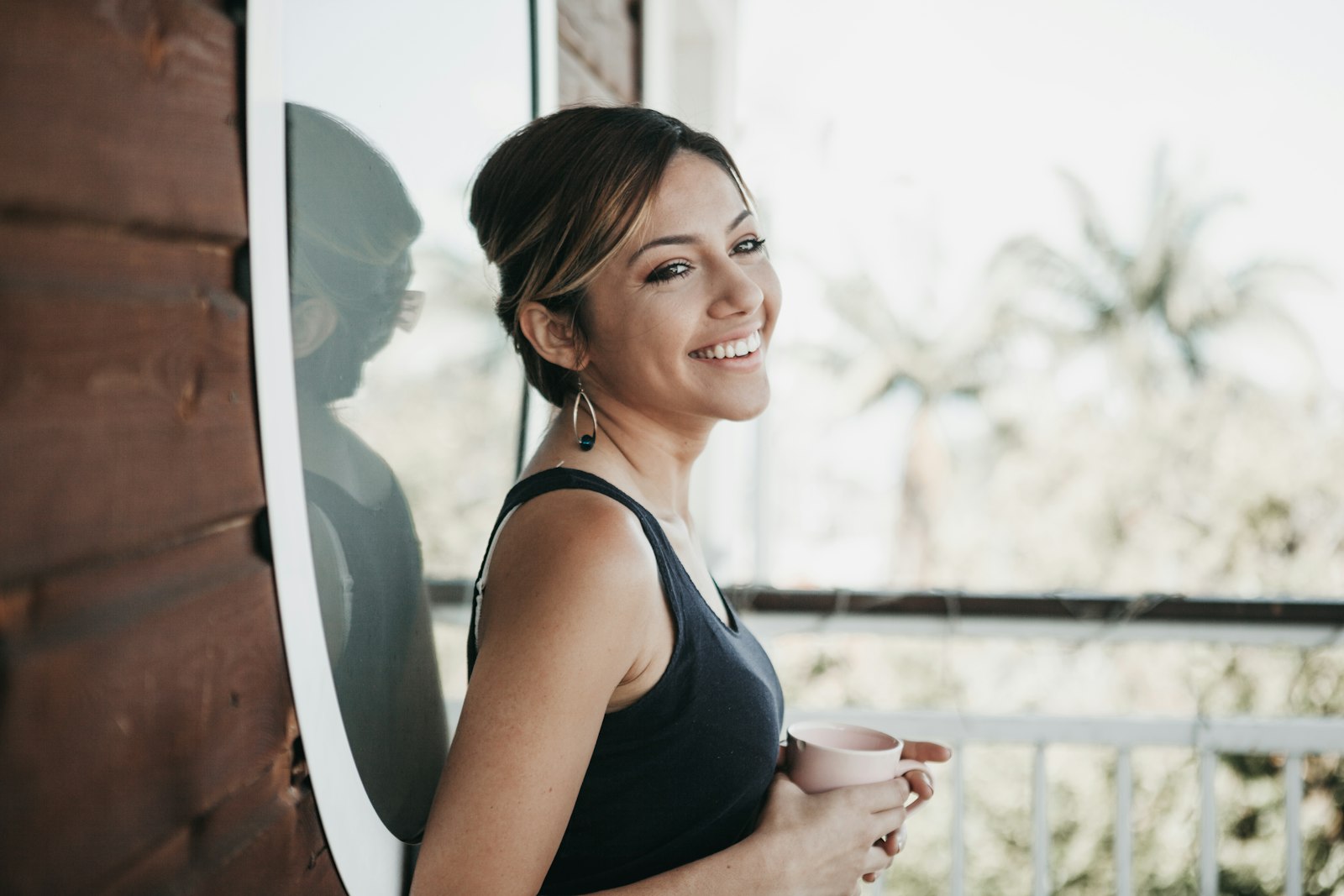 A woman at home by a window, at ease after sorting out her debt