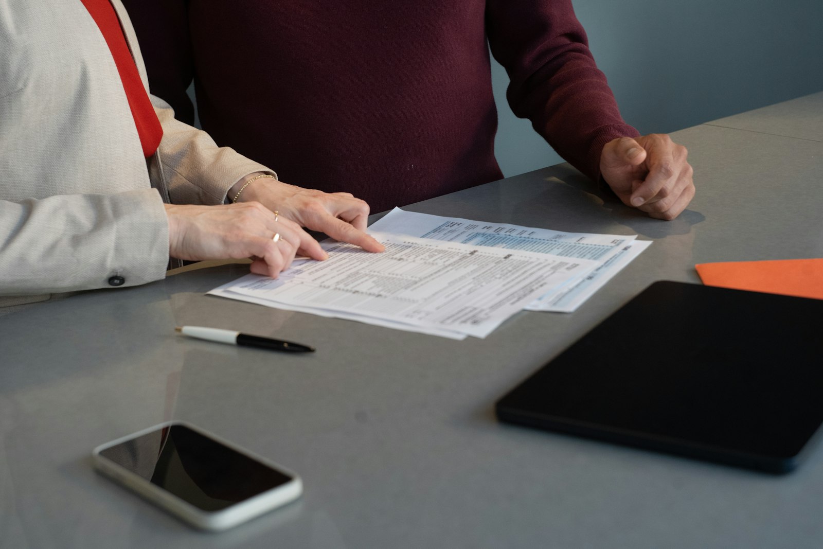Two people going through paperwork together at a table